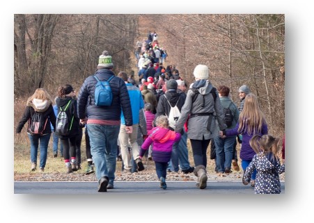 A group of people walking on a road Description automatically generated with medium confidence