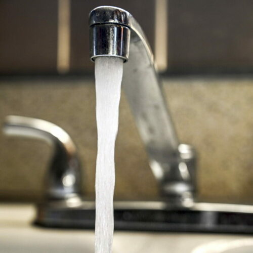 A faucet running water in a home in Bethpage, New York water running out of a sink faucet