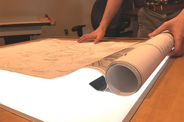 Blueprints being laid out on a light table
